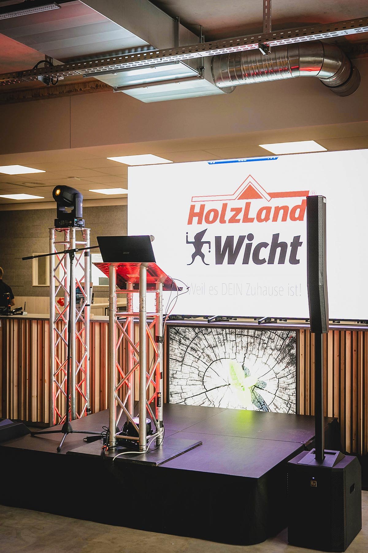 Kleine Bühne mit kompaktem PA-Soundsystem und stehend montierter LED-Videowand im Hintergrund.